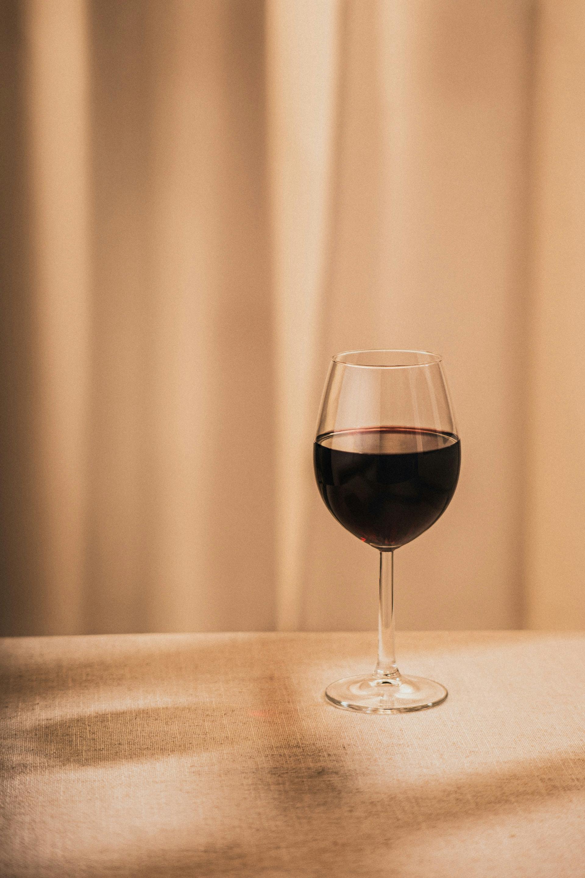 Weinglas mit dunkelroter Flüssigkeit drinnen