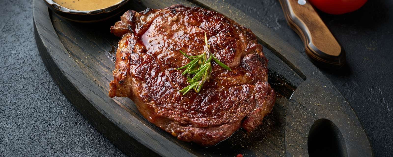 Steak mit Sauce auf Holzbrett