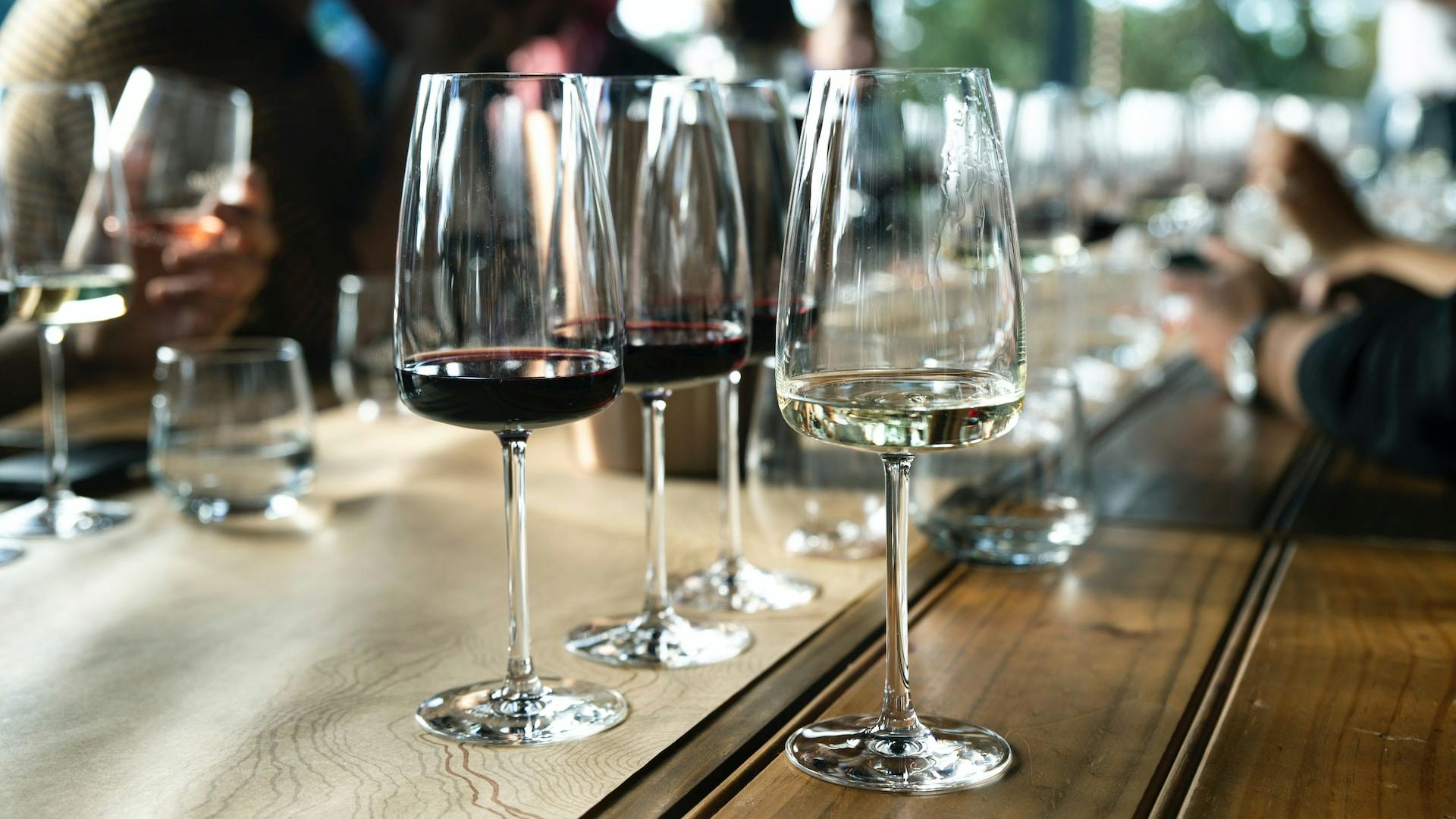 Rot- und Weißweingläser mit roter und durchsichtiger Flüssigkeit auf einem Tisch