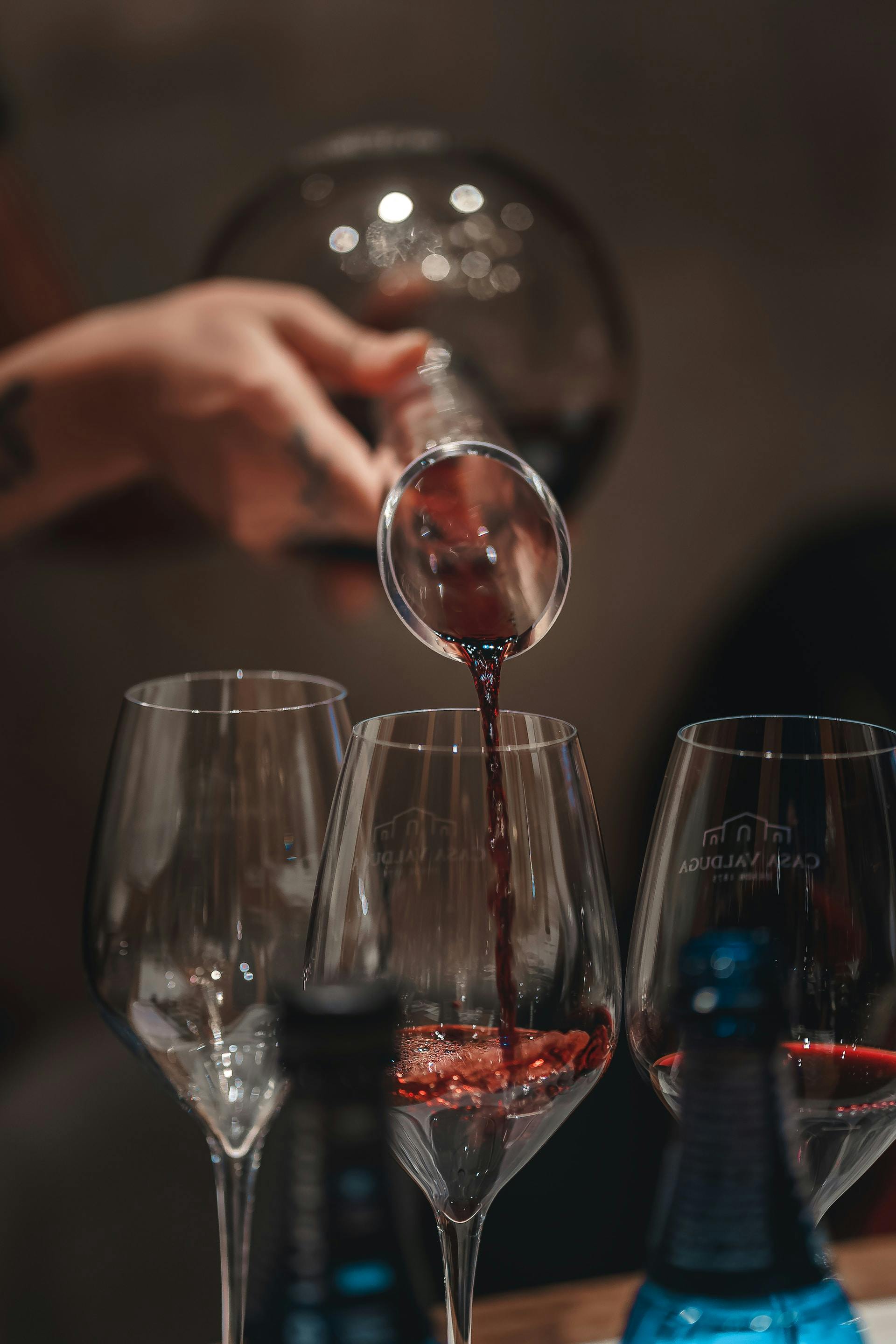 Aus einer Weinkaraffe wird Rotwein ins Glas eingeschenkt