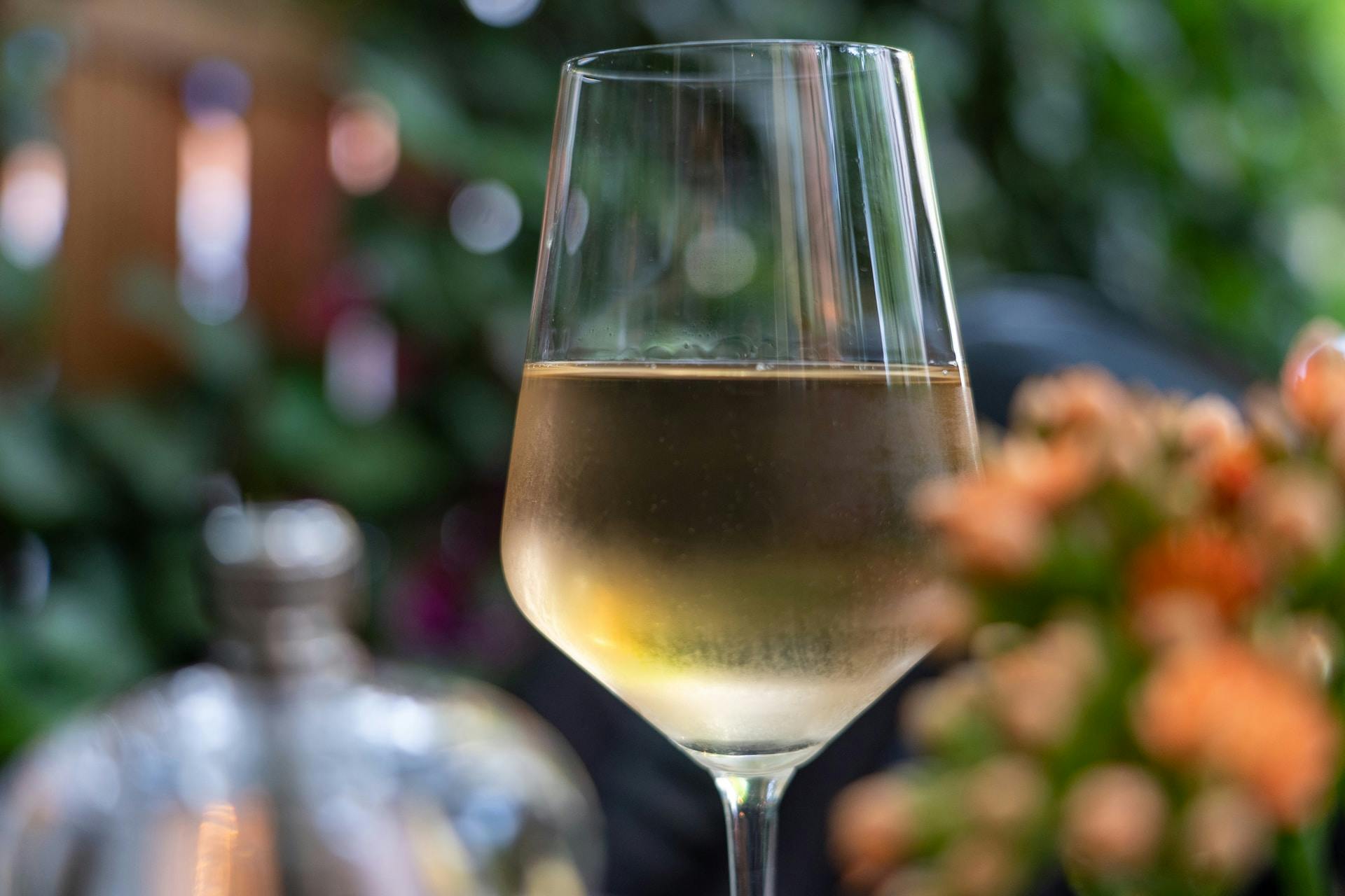 Klares Weinglas mit gelblicher Flüssigkeit 