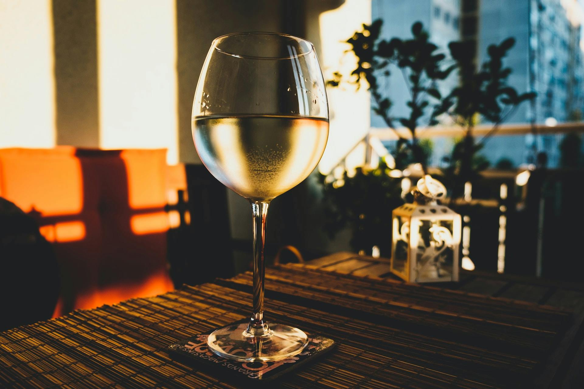 Weinglas auf Tisch mit klarer Flüssigkeit drinnen