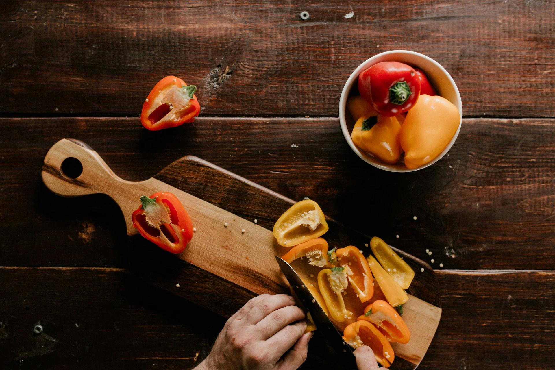 Auf Holzbrett Gemüse mit Messer geschnitten
