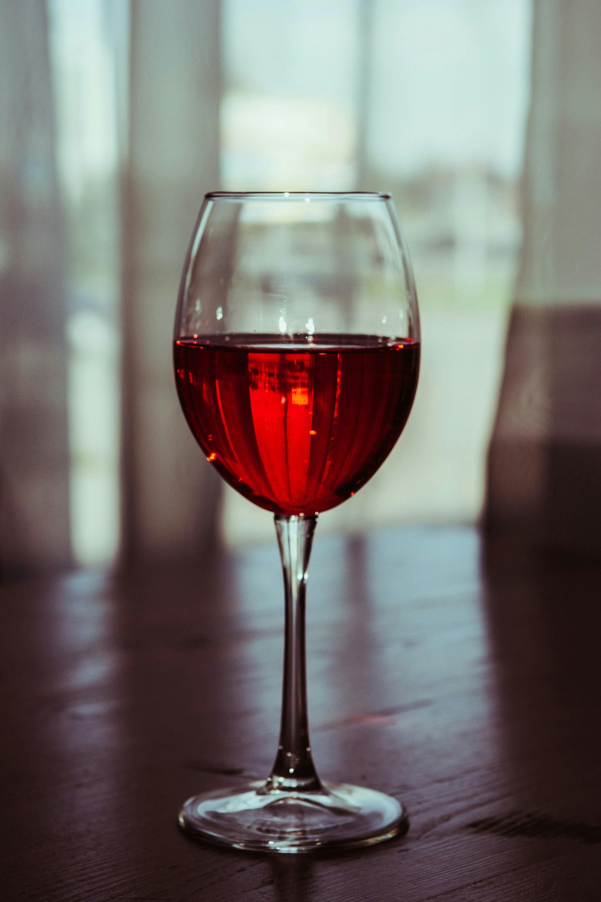 Ein Glas gefüllt mit roter Flüssigkeit steht in der Mitte des Bildes.
