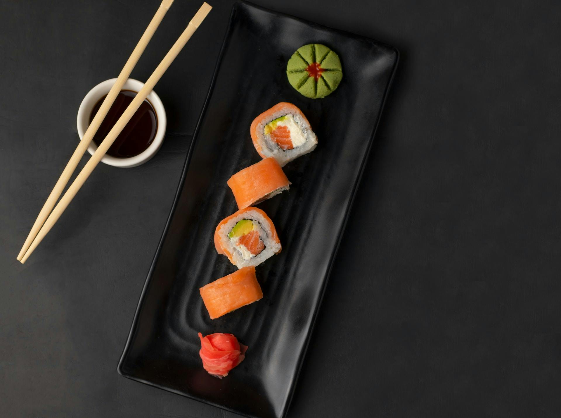 Sushi in Einer Reihe Auf Schwarzem Teller Von Oben