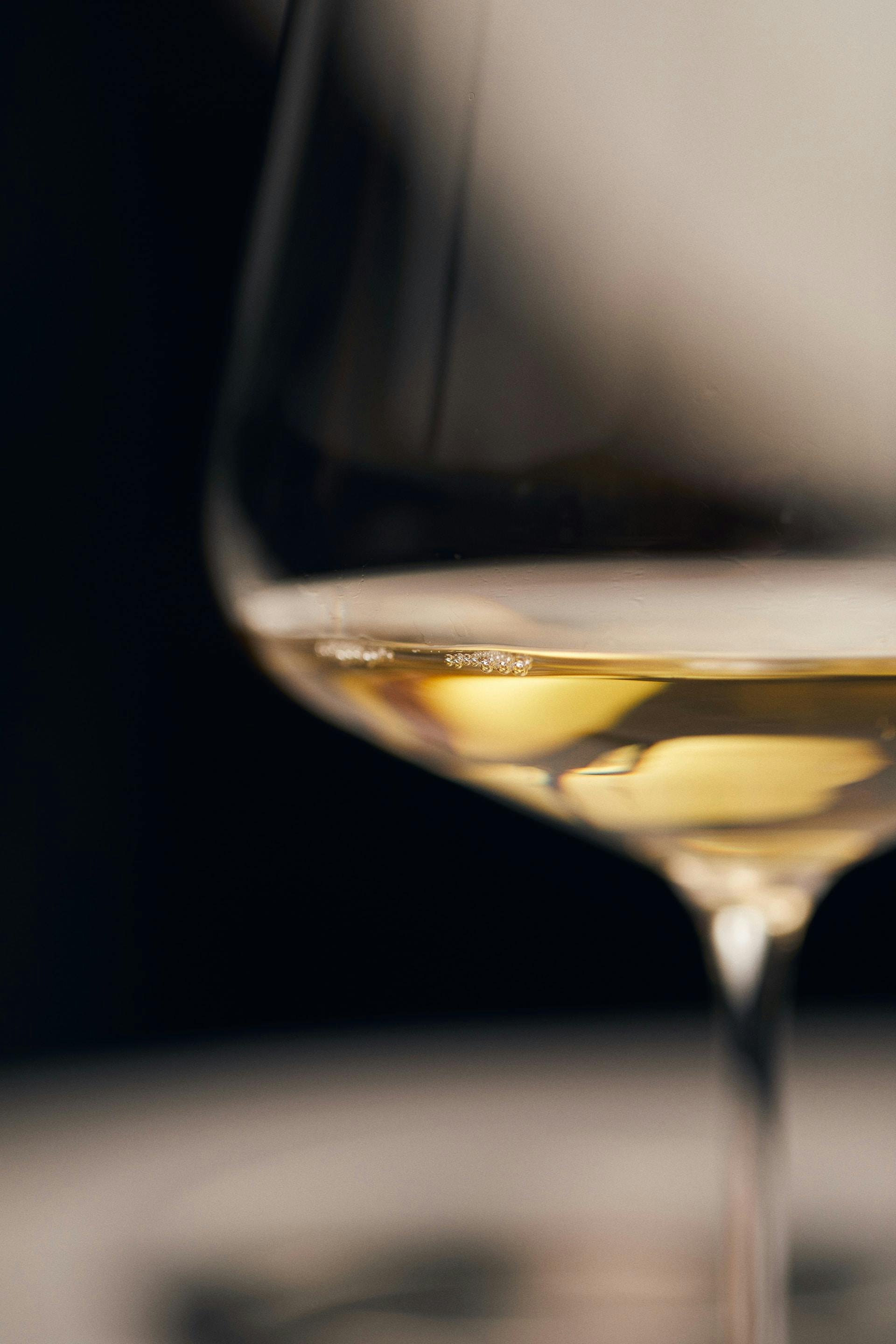 Weißweinglas mit klarer gelber Flüssigkeit 