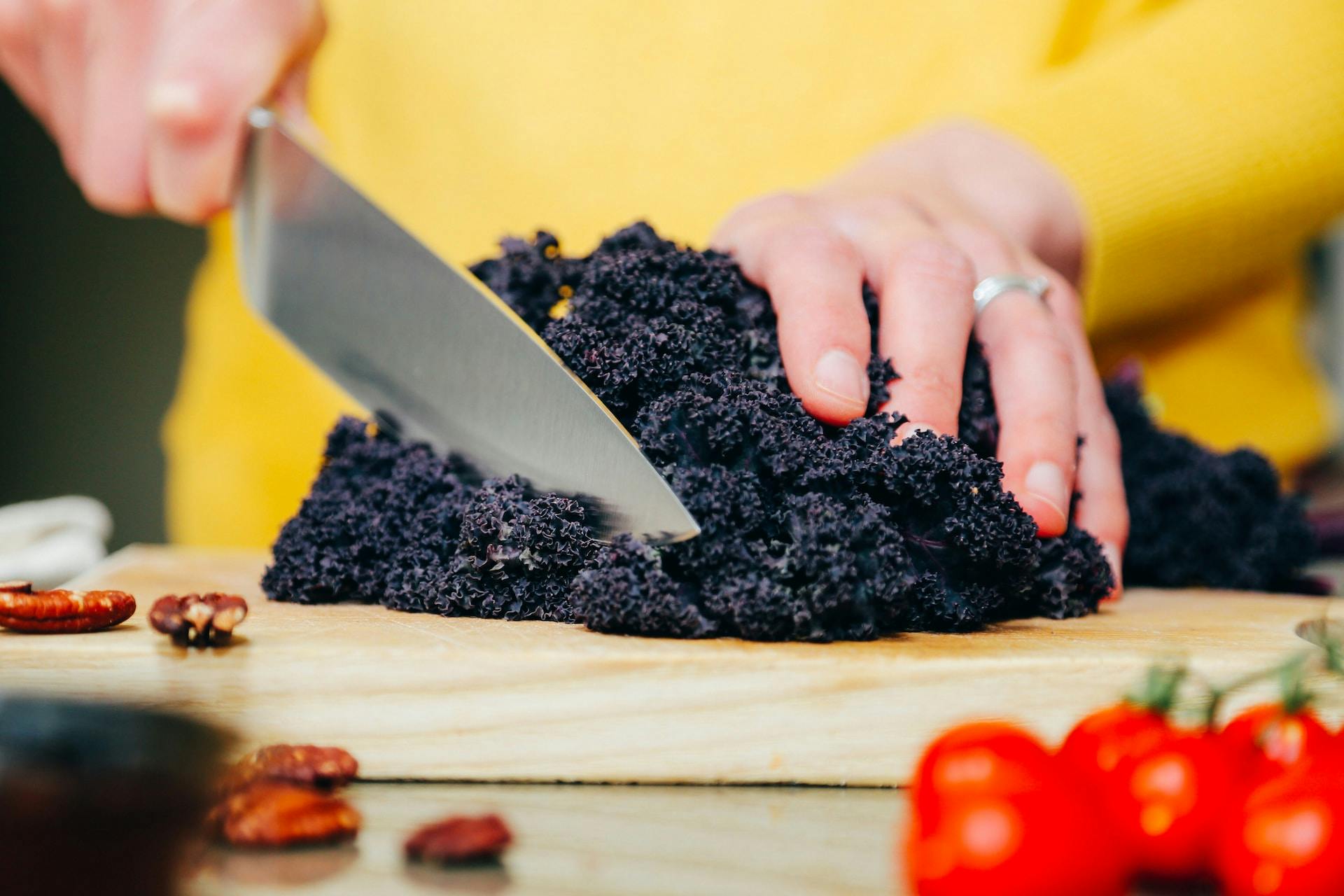 Auf Holzbrett Messer schneidet schwarzes Gemüse
